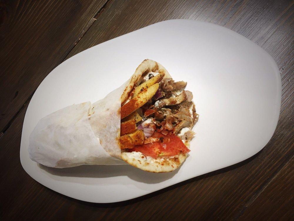 Traditional Pork Gyro · Just like in Greece! 
Hand-stacked marinated pork topped with tomatoes, red onions, and house-made tzatziki, topped with seasoned fries and paprika.