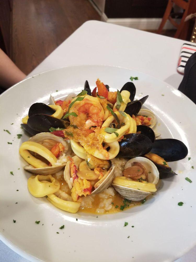 Seafood Risotto · Fresh Maine lobster, wild Maine mussels, gulf shrimp, little neck clams and calamari served over classic white risotto in a white wine saffron broth.