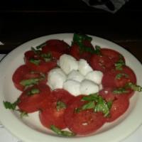Caprese Salad · Fresh mozzarella and Roma tomatoes dressed with fresh basil and extra virgin olive oil. Glut...
