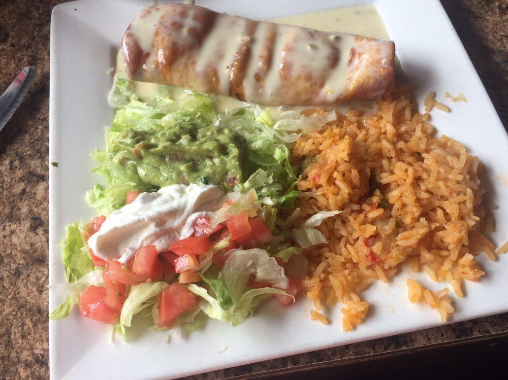Chimichanga · Flour tortillas deep fried, filled with shredded beef or chicken. Topped with lettuce, tomatoes, sour cream, nacho cheese, and guacamole. Served with rice or beans.