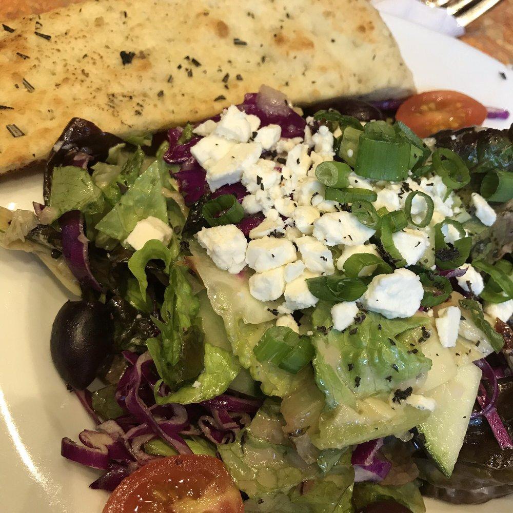 Greek Salad · Romaine, red cabbage, red leaf lettuce, feta, cucumber, roasted artichokes, oregano, green onions, grape tomatoes, kalamata olives, and housemade red wine vinaigrette