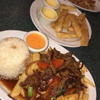 Lomo Saltado Limeno · Sauteed steak cooked in wok with onions and tomatoes accompanied with french fries and garli...