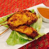 Chicken Satay · Strips of chicken breast grilled on bamboo skewers and served with a side of peanut sauce.
