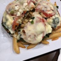 Greek Pizza · Spinach, feta, tomato on pita topped with melted mozzarella served with french fries.