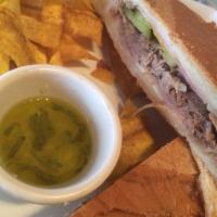 Cuban Sandwich · Slow roasted pork with ham, Swiss cheese and pickles served with french fries.