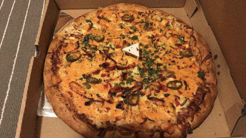 Butter Chicken Pizza · Pizza sauce, Tandoori chicken, onions, green bell peppers, makhani sauce, fresh garlic, ginger, and cilantro.