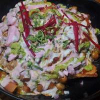 Samosa Chaat · Samosa topped with chick peas onions, tomatoes, coriander and crunchy noodles. Drizzled with...