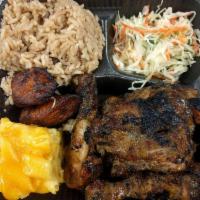 Jerk Chicken · Served with rice & peas, macaroni pie and sauteed cabbage or spinach.