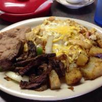 Migas · Eggs scrambled with crispy tortilla strips, onions and tomatoes. Topped with cheese. Served ...