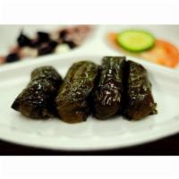 Dolmas · Grape leaves stuffed with rice and flavoured with mint and lemon topped with savoury tomato ...
