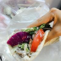 Gyro Sandwich · Sliced Mediterranean spiced beef with red onion, lettuce, and tomato on warm pita bread topp...
