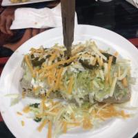 Burrito Grande · Flour tortilla rolled and stuffed with refried beans, Mexican rice, queso, slice jalapenos a...