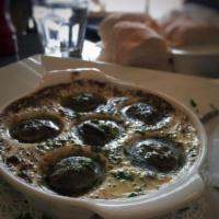 Escargot · Half dozen snails (no shells) in a delicious garlic butter, served with bread 