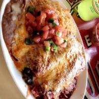 Enchiladas · 2 corn tortillas rolled filled out and cover with red sauce, melted cheese, rice, beans, pic...