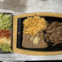 Carne Asada · Marinated succulent steak served with beans and rice on the side.
