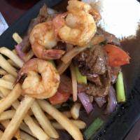 Lomo Candela · Sauteed beef strips and shrimp with onions and tomatoes served with french fries and white r...
