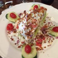 Wedge Salad Dinner · Iceberg lettuce, tomato, bacon, blue cheese crumbles and red onions with blue cheese dressing.