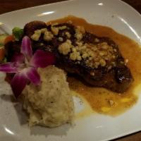 Grilled Angus New York Strip Steak Dinner · Topped with Gorgonzola cheese and brown sauce. Served over mashed potatoes and mixed vegetab...