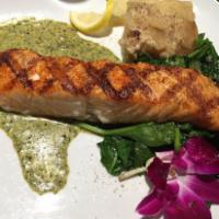Grilled Salmon Dinner · Served over sauteed spinach, scalloped potatoes, and basil pesto sauce.
