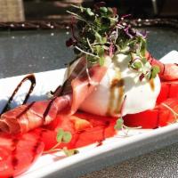 Burrata · Fresh burrata topped over vine ripe tomatoes and roasted yellow peppers. Topped with a homem...