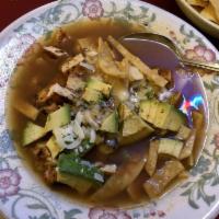 Tortilla Soup · Pieces of pollo asado and fresh avocado with tortilla strips and shredded cheese in rich chi...