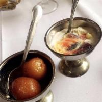 Gulab Jamun · Solidified milk balls, deep-fried, soaked in sugar syrup and served hot.