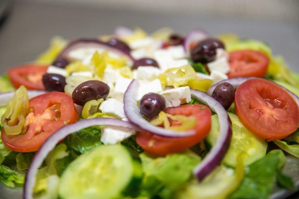 Greek Salad · Romaine lettuce, tomatoes, onions, cucumbers, pepperoncini pepper, Kalamata olives and feta cheese.