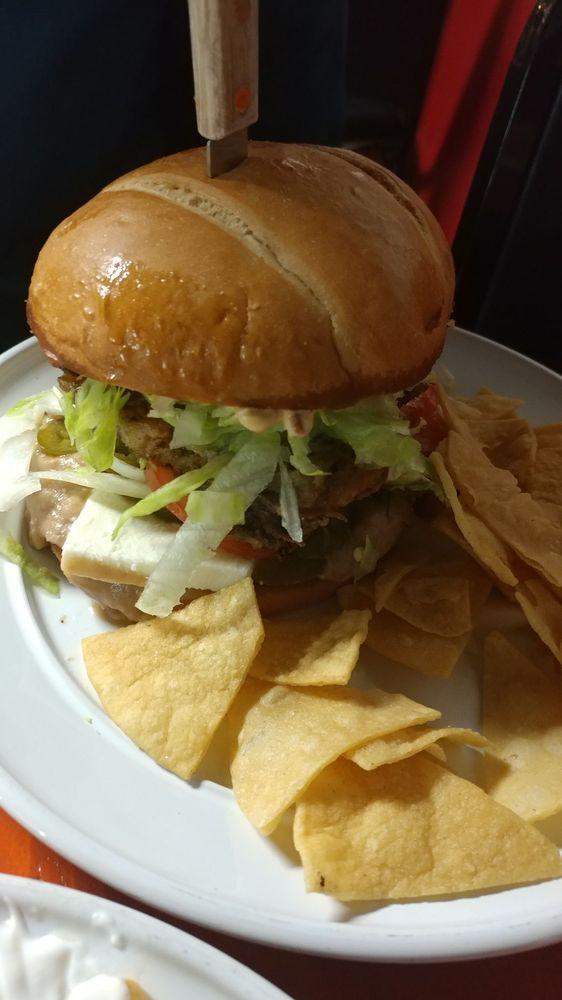 Torta Cubana · Carnitas, milanesa, refried beans, lettuce, tomato, onion, jalapeño, avocado, queso fresco and signature aioli served with a side of home made chips.