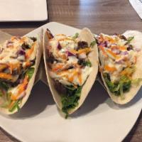 Korean Tacos · Spicy chicken or marinated ribeye over 3 warm flour tortillas filled with crisp lettuce and ...