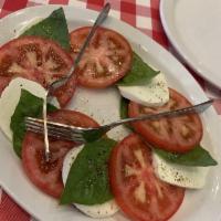Caprese Salad · Slices of fresh mozzarella, tomatoes and fresh basil, drizzled with extra virgin olive oil.