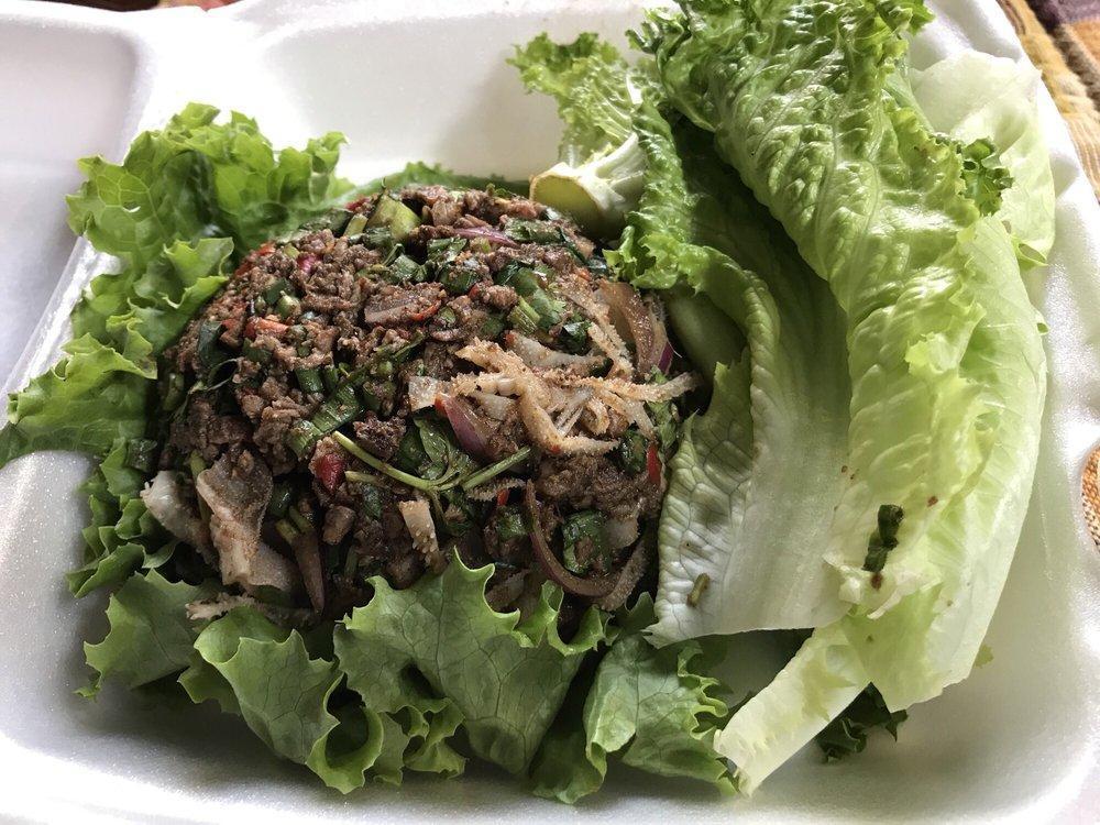 Beef Laap · Chopped grilled beef mixed with sliced purple onion, green onion, cilantro, mint, Thai chili (optional) and toasted rice seasoned in an exquisite lime dressing. Served with cabbage.