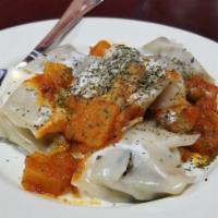 Mantu · Steamed dumplings filled with ground beef and onions, topped with lentils, and mint garlic y...