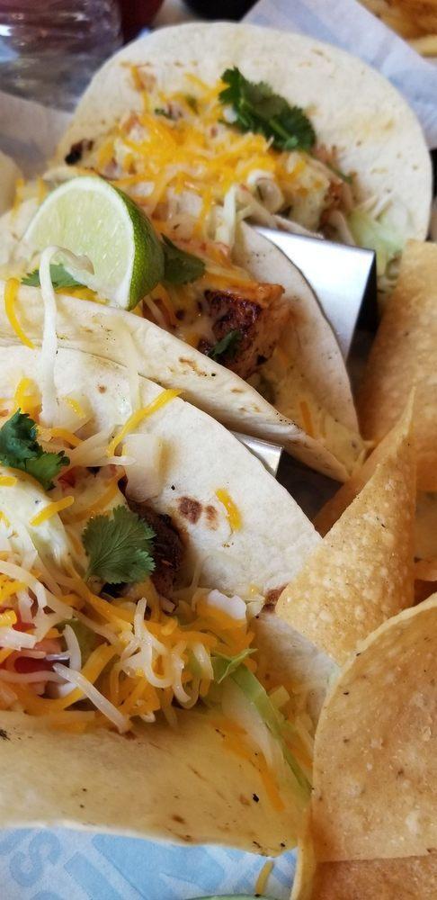 Mahi Mahi Tacos · Blackened mahi mahi,  with green cabbage, cilantro, tomatoes, shredded cheese, and avocado lime dressing on flour tortilla. Served with queso and tortilla chips.