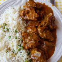 Goat Curry · Pieces of Boned Goat meat cooked in a curry sauce with a blend of spices. Served with rice.