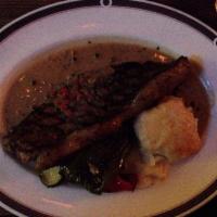 Steak Au Poivre · 12 oz NY strip steak in a crushed peppercorn and cognac sauce with seasonal vegetables and h...