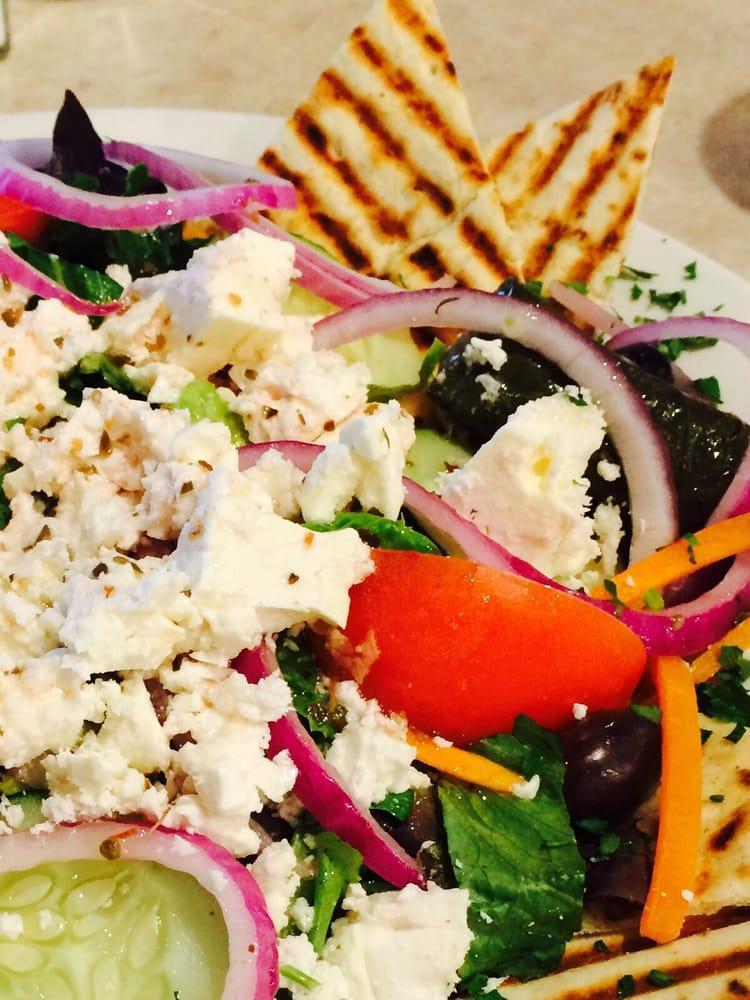 Greek Salad · Lettuce, tomatoes, cucumbers, onions, peppers, Kalamata olives, feta cheese with stuffed grape leaves and pita wedges.