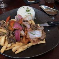 Lomo Saltado · Fillet mignon sauteed with red onions and tomatoes, served with rice and french fries.

