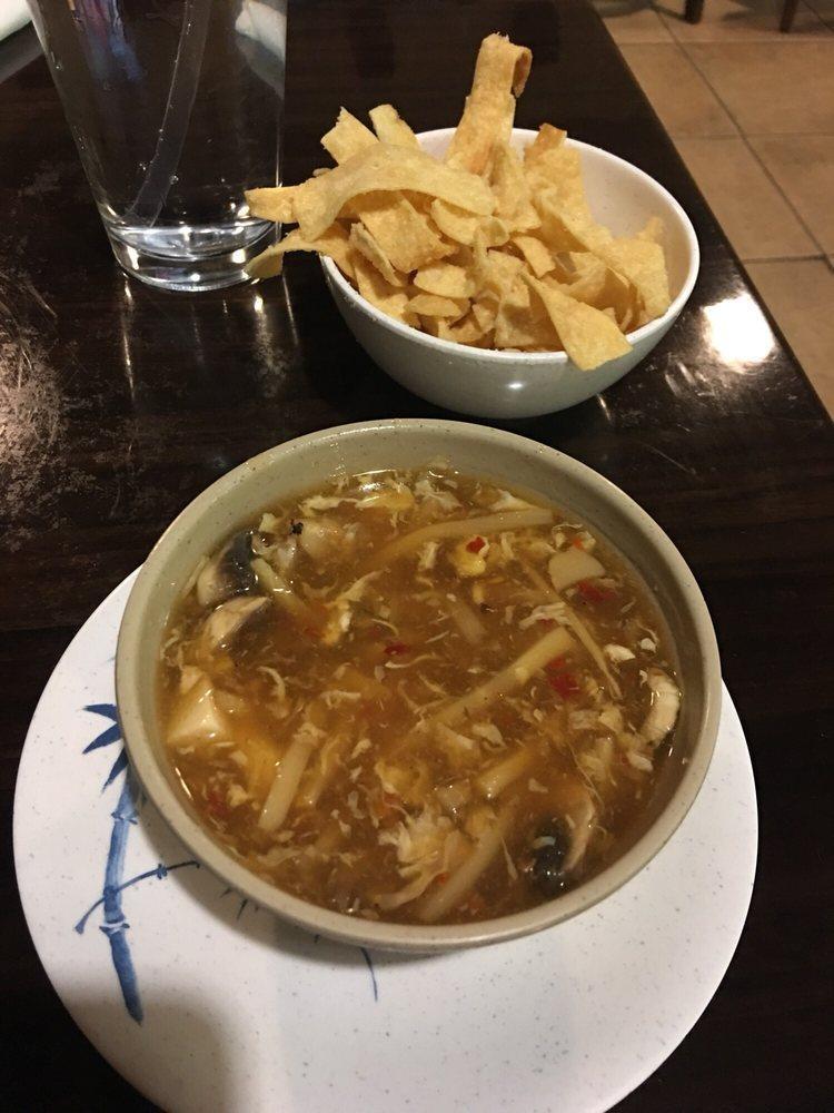Hot & Sour Soup · Mushrooms, steamed tofu, bamboo shoots, and silky beaten eggs, simmered in a spicy house-made broth. Served with a side of fried noodles.