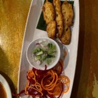 Chicken Satay · Grilled marinated chicken skewers served with homemade peanut sauce and a fresh cucumber rel...