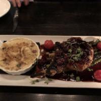Grilled Apple Brined Pork Chop · Sweet potato puree, grilled asparagus, balsamic smoked blue cheese butter, and red wine demi...