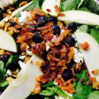 Raspberry Spinach Salad · Topped with goat cheese, walnuts, bacon, apples, and blueberries, served with homemade raspb...