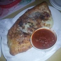 Calzone · Filled with mushrooms, onions and cheese with side of marinara sauce.