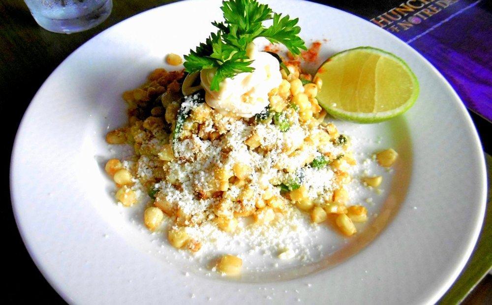 Esquites · Roasted corn salad with epazote, topped chili powder, mayonnaise and sprinkled with Cotija cheese.
