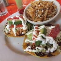 Tostada · Crunchy flat shell, refried beans, stuffing of your choice. Served with lettuce, tomatoes, q...