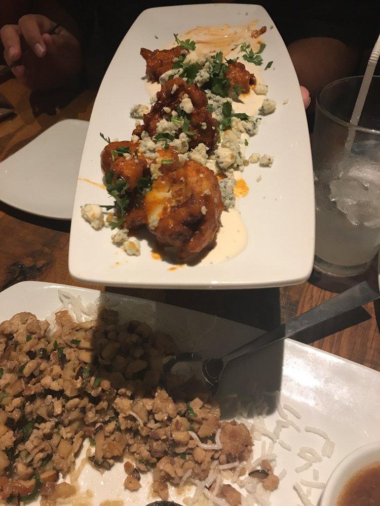Spicy Buffalo Cauliflower · Fresh cauliflower florets buttermilk-battered and fried to a golden brown, then tossed in housemade Sriracha Buffalo sauce and topped with a salad of celery, cilantro, scallions and Gorgonzola. Vegetarian.