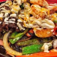 Fajitas Vallarta · Chicken, 3 jumbo shrimps and chorizo with sauteed peppers, onion and tomato, topped with 3 c...
