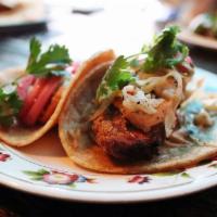 Fried Chicken Tacos · Baja style beer-battered chicken, smoked cabbage slaw, ghost pepper mayo, and cilantro