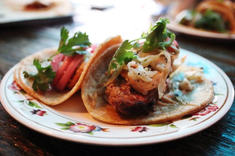 Fried Chicken Tacos · Baja style beer-battered chicken, smoked cabbage slaw, ghost pepper mayo, and cilantro