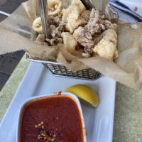 Fried Calamari · Lightly floured calamari served with lemon and spicy tomato sauce on the side.