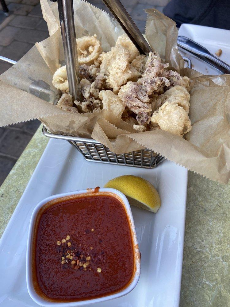 Fried Calamari · Lightly floured calamari served with lemon and spicy tomato sauce on the side.